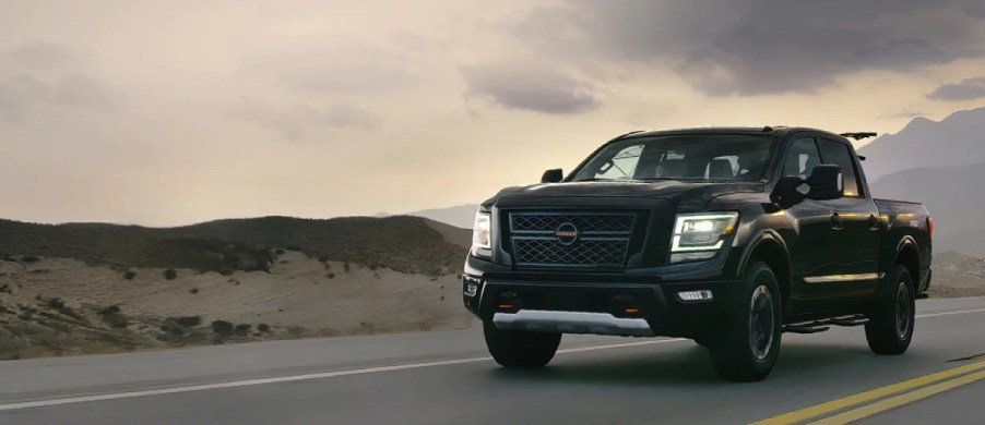 A black 2021 Nissan Titan driving past the mountains.