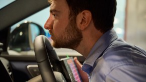 The 'Nose of Nissan,' Peter Karl Eastland, sniffs a steering wheel in a Nissan car