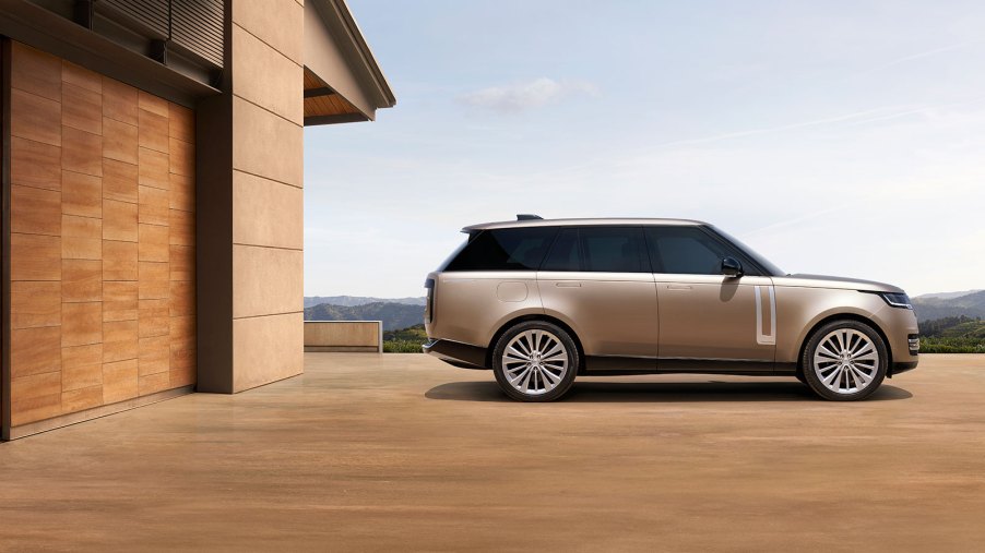 A gold 2022 Land Rover Range Rover parked in front of a house.