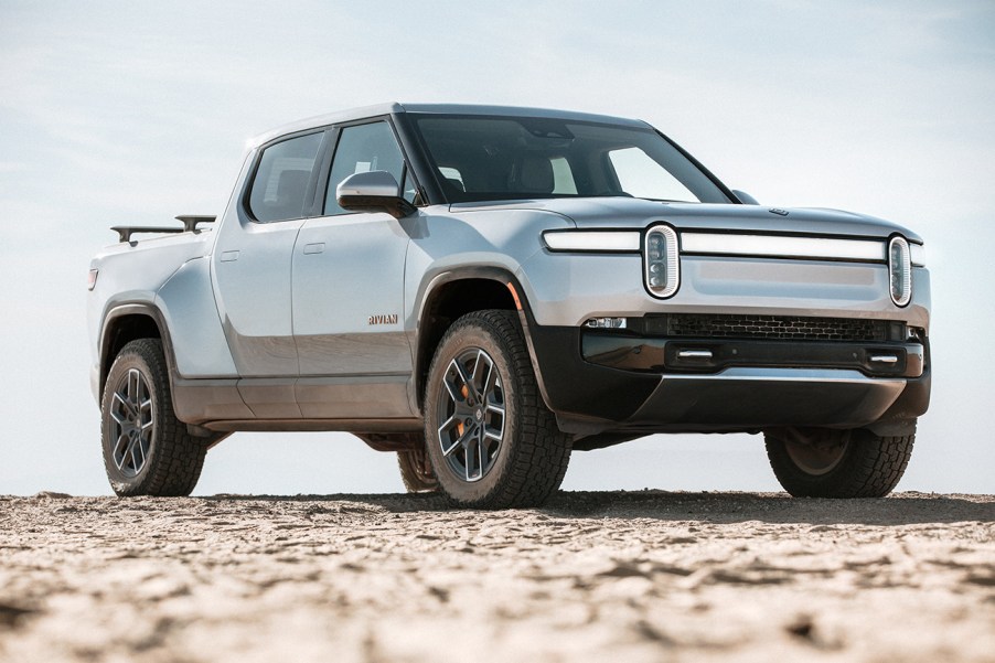 Rivian R1T electric truck in silver, parked on hill crest with dirt on tires. The Rivian IPO is expected to raise $8 billion for the EV truck maker