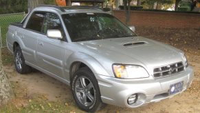 A silver Subaru Baja Turbo parked outside near a tree