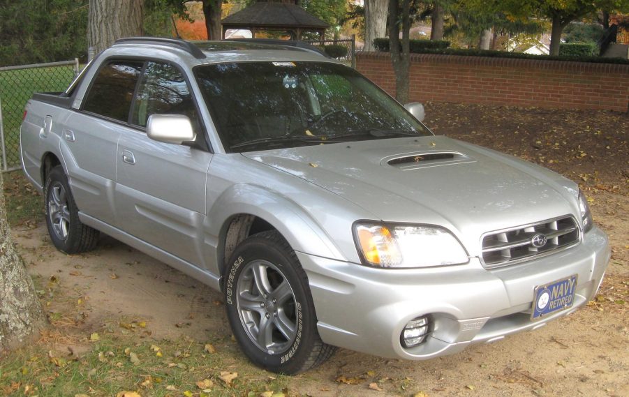 A silver Subaru Baja Turbo parked outside near a tree