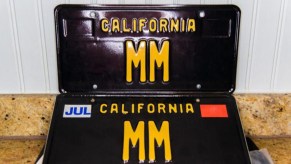 Two black and yellow California vanity license plates with the letters "MM"