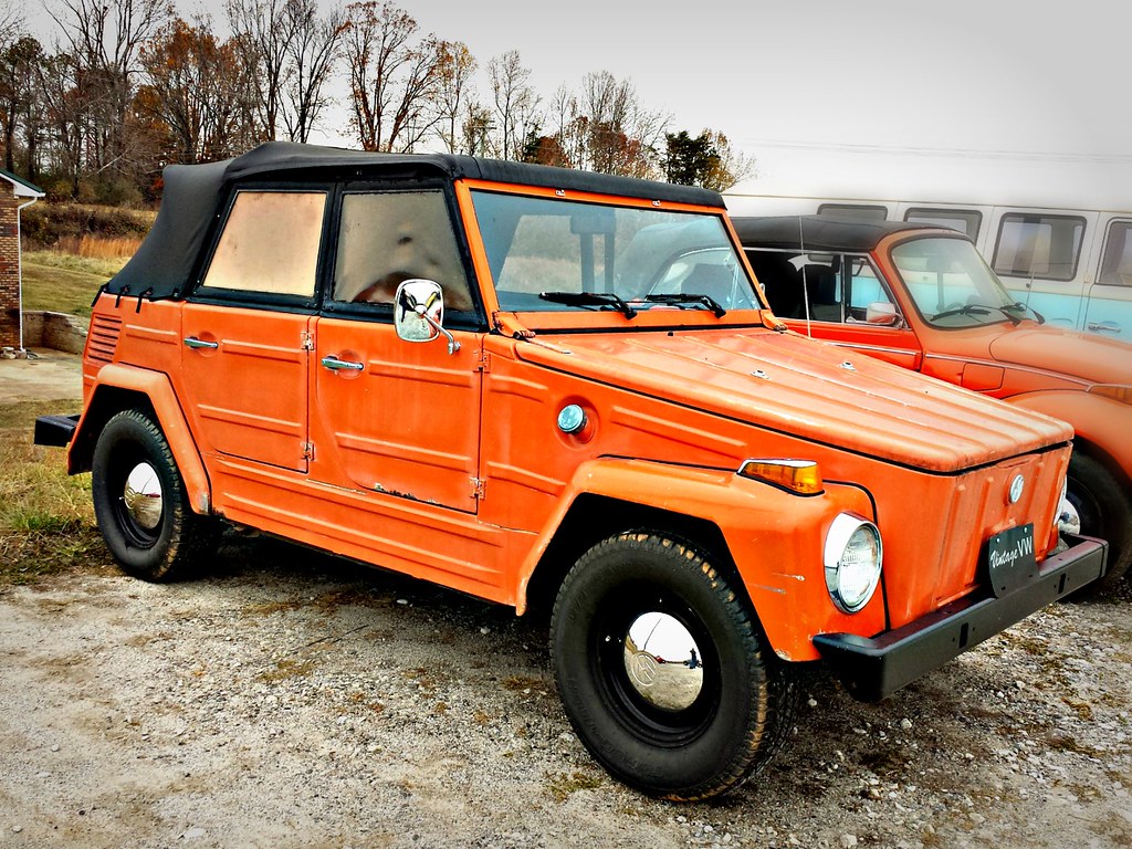 Orange Volkswagen thing parked outside near trees