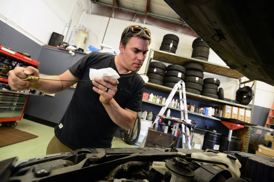 A man checks a car's oil