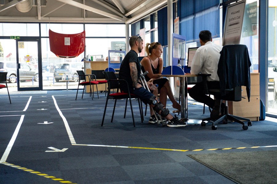 customers sitting a car salesperson's desk