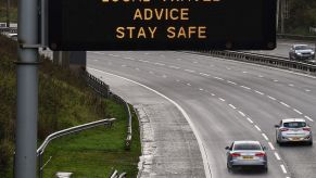 Cars passing a highway traffic safety sign in Glasgow, Scotland