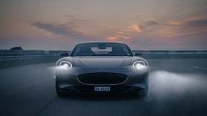 A grey Piech GT shot from the front on an airfield at dusk