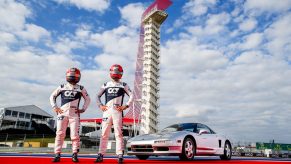 Pierre Gasly and Yuki Tsunoda stand in front of a silver Acura NSX at the Circuit of the Americas