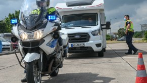 a police officer on a bike pulls over an RV camper