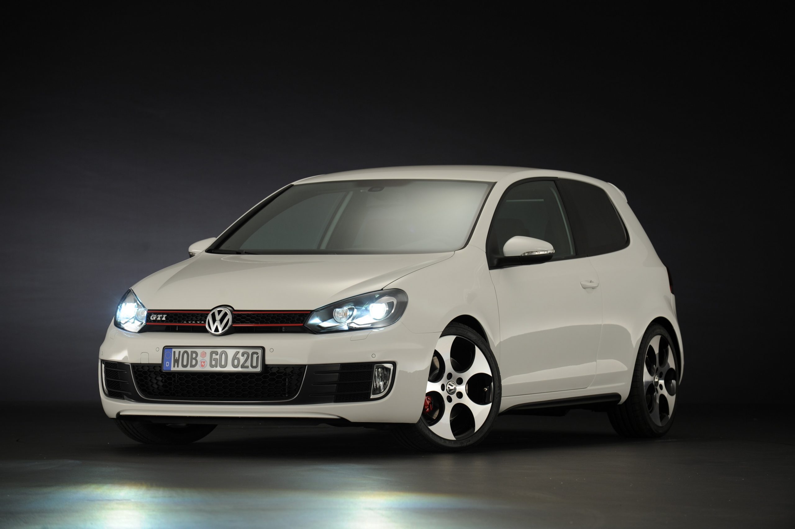 A white Volkswagen GTI shot in a photo booth from the front 3/4