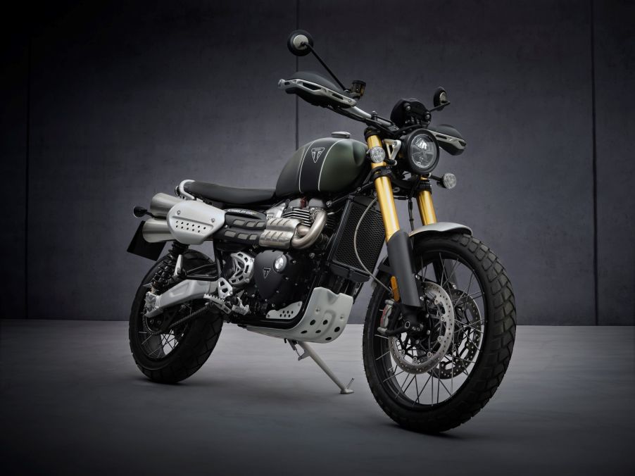 A green-and-black 2021 Triumph Scrambler 1200 XE in a gray studio