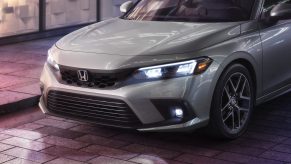 A white 2022 Honda Civic sedan shot at night on a city street from the nose forward