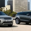 A gold and a gray 2022 Land Rover Range Rover Evoques parked with a city in the background.