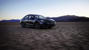 A dark blue 2022 Subaru WRX shot from the front 3/4 on a dry lake bed