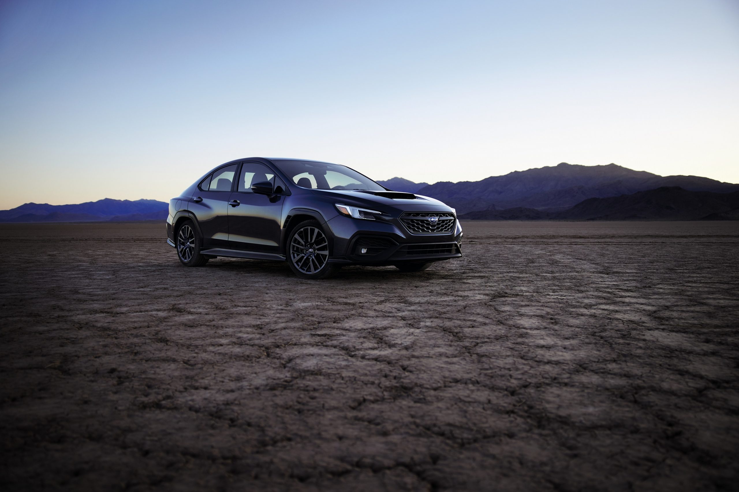 A blue WRX shot on a dry lake bed from the 3/4 angle