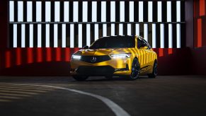 The front 3/4 view of the yellow 2023 Acura Integra Prototype in a garage