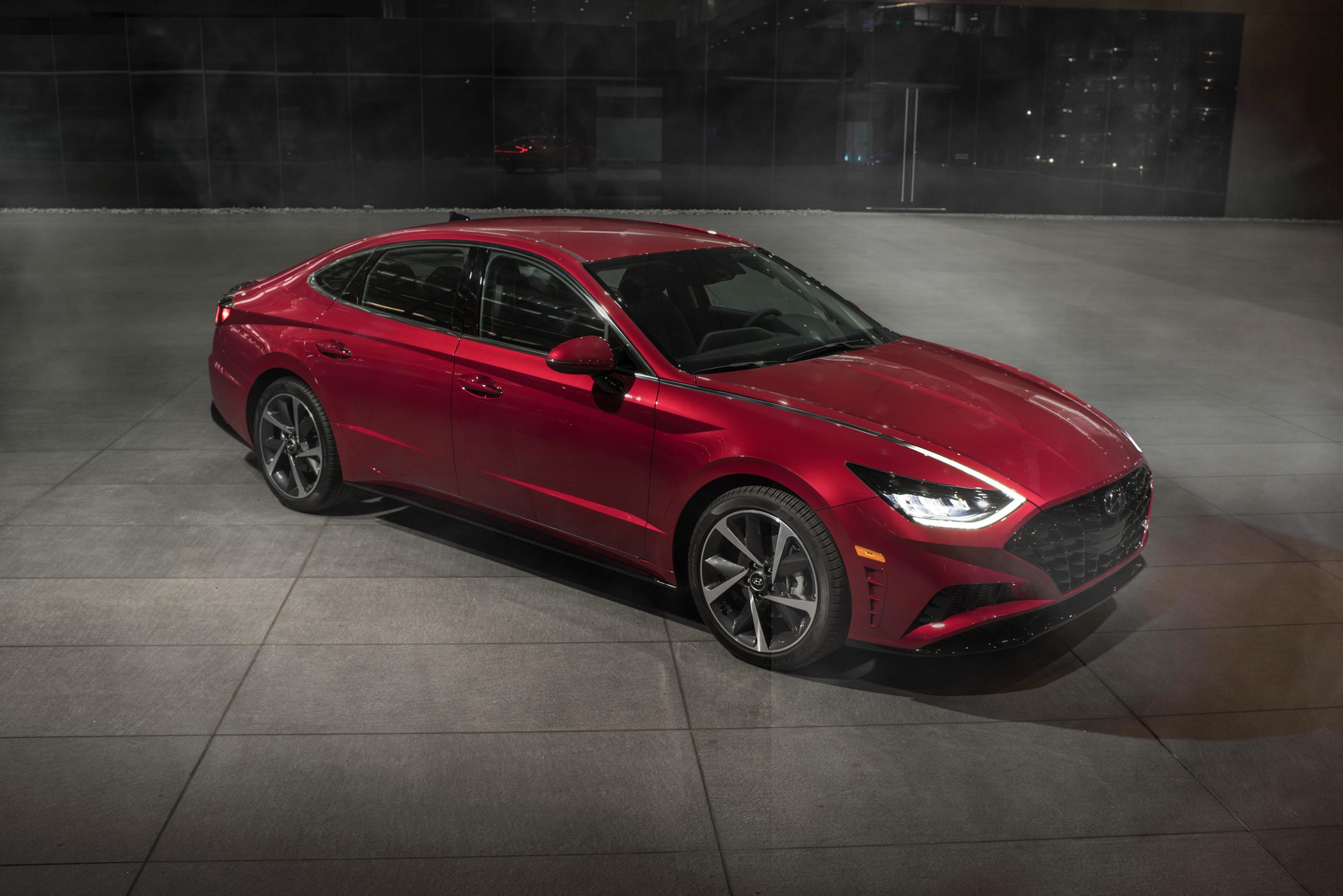 A red 2022 Hyundai Sonata shot from the high 3/4 angle at night