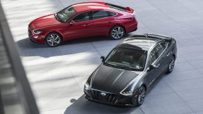 A pair of 2022 Hyundai Sonata mid-size sedan models in red and black