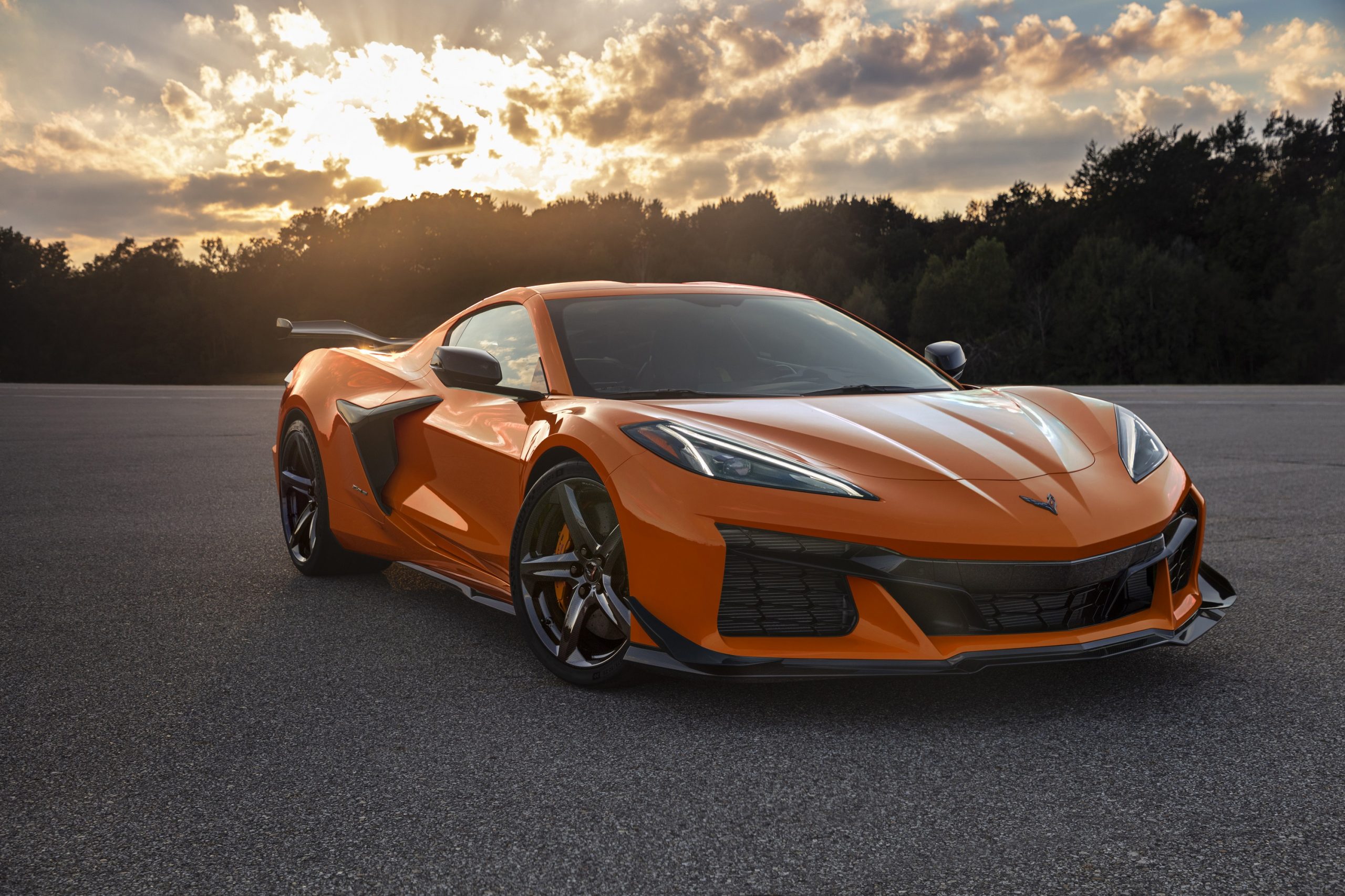 An orange Chevrolet Corvette shot from the front 3/4 at sunset