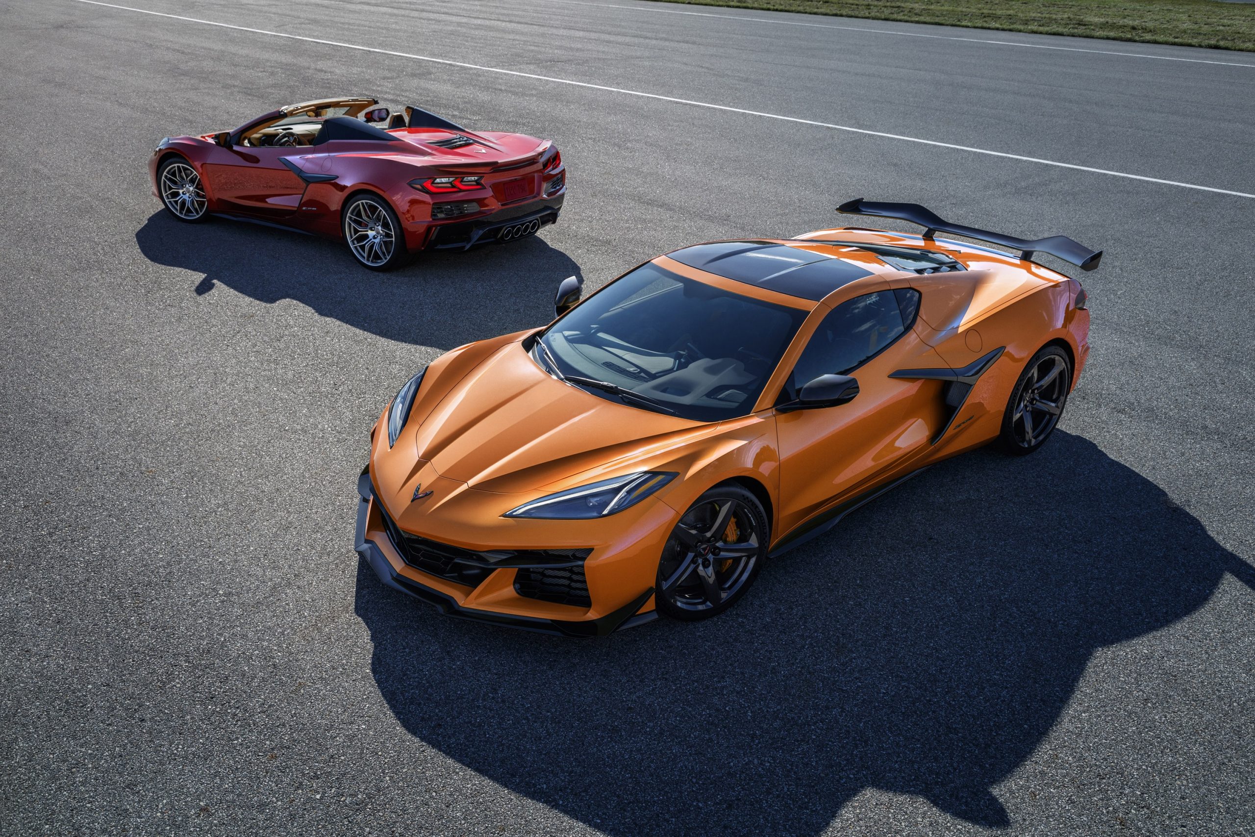 An orange and red pair of Corvette Z06 models shot from the high 3/4