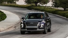 Black 2022 Hyundai Palisade, a good SUV for sleep, driving on a curvy road