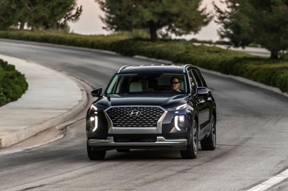 Black 2022 Hyundai Palisade, a good SUV for sleep, driving on a curvy road