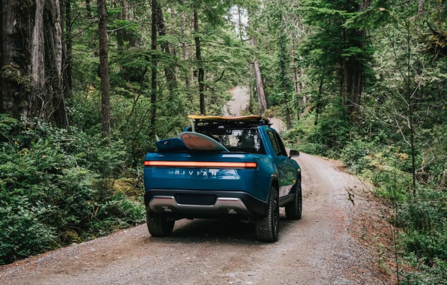 Blue Rivian R1T driving through a forest