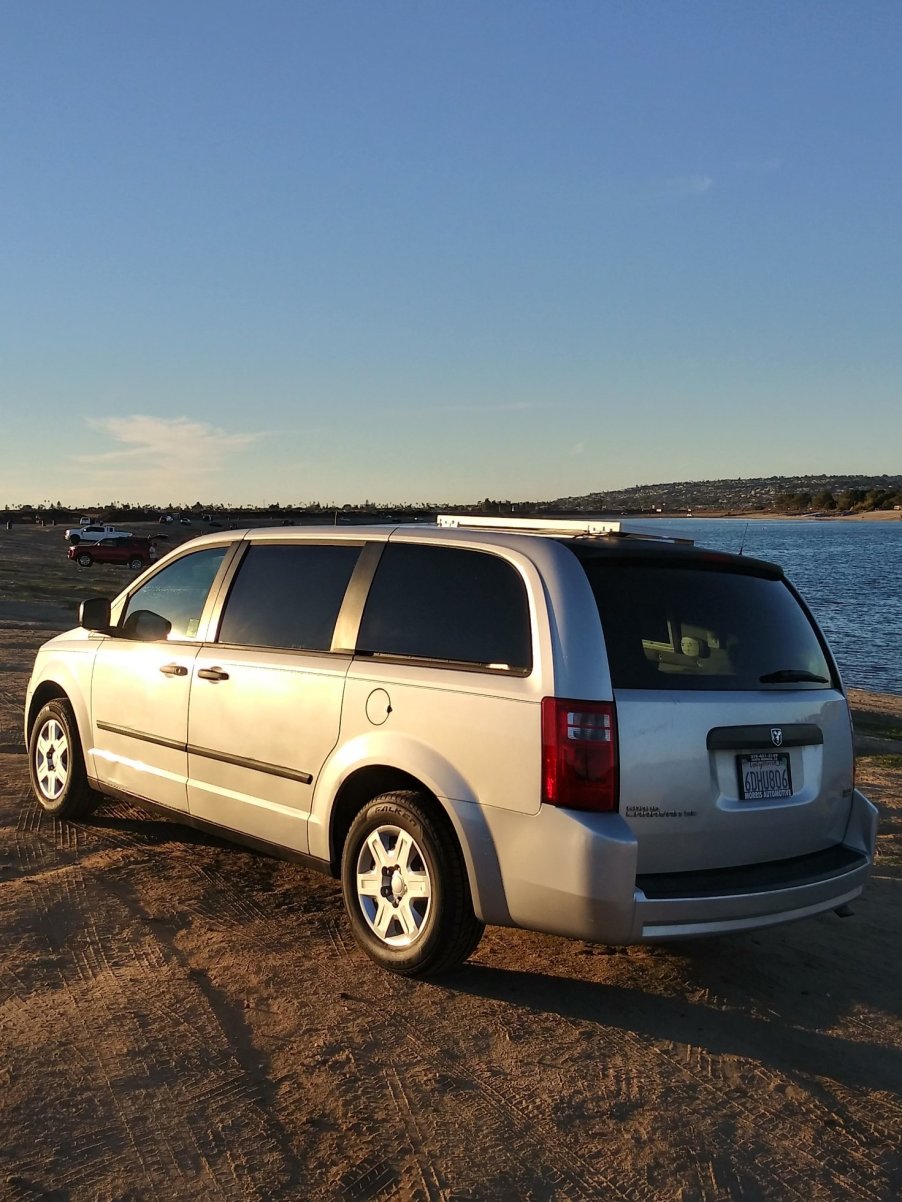 2008 Dodge Grand Caravan secret conversion camper van parked next to some water