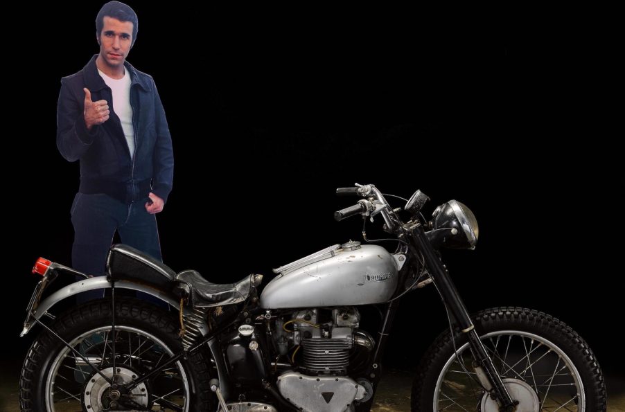 A cut out of Happy Days, The Fonz, sitting up next to Fonzie's Motorcycle, a 1949 Triumph TR5 built by Bd Ekins