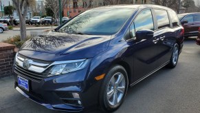 A blue Honda Odyssey is parked.