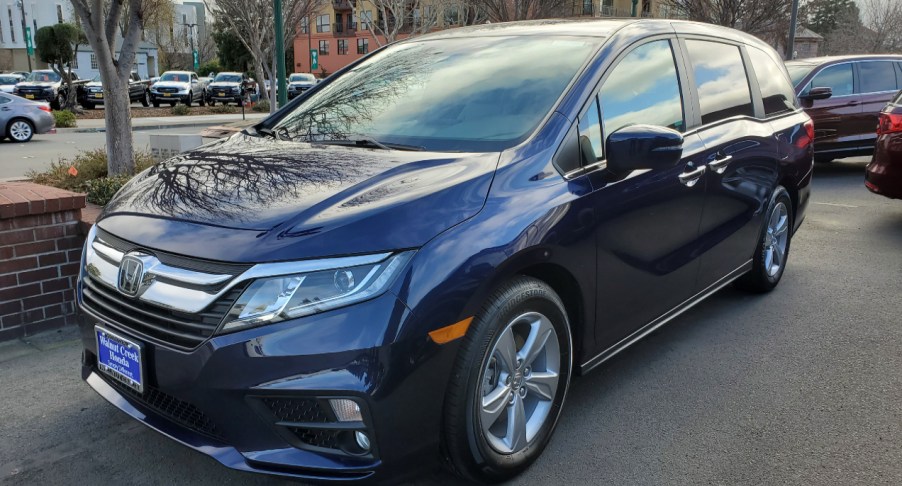 A blue Honda Odyssey is parked.