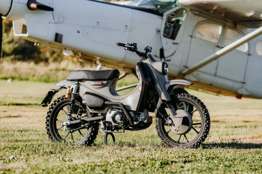 The gray MAAN Motocicli Audacti 2021 Honda Super Cub 125X in a grassy field