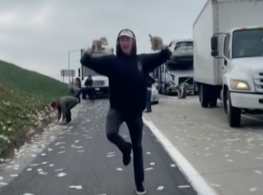 Man running with cash after armored truck rained money on a Califorina highway