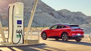 Red 2022 Ford Mustang Mach-E parked next to a charging station