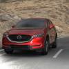 Red 2022 Mazda CX-5 driving on a curvy road