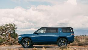 Rivian Blue 2022 Rivian R1S EV SUV driving off-road in the desert