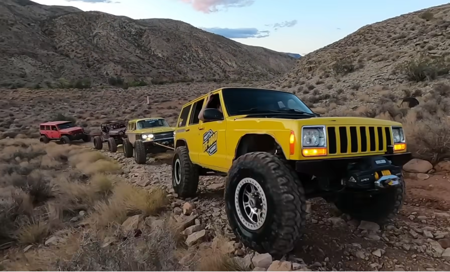 Convoy pulling a dead Jeep out of the river