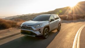 Silver Sky Metallic 2022 Toyota RAV4 Hybrid driving on a curvy road