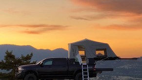 The side view of a Skinny Guy Camper mounted on a black Ram 2500 in the desert