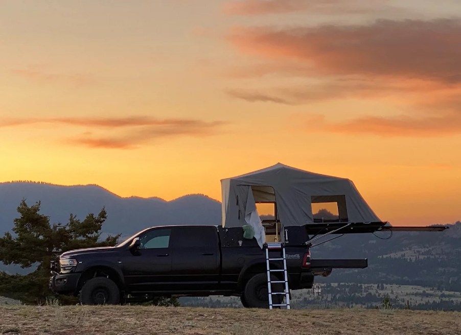 The side view of a Skinny Guy Camper mounted on a black Ram 2500 in the desert