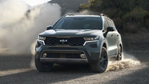 A dark gray 2022 Kia Sorento driving on a gravel road.