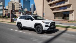 Super White 2022 Toyota RAV4 driving on a city street