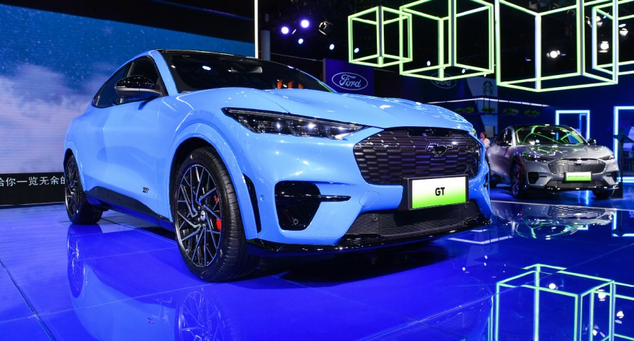 A blue Ford Mustang Mach-E electric SUV is on display.