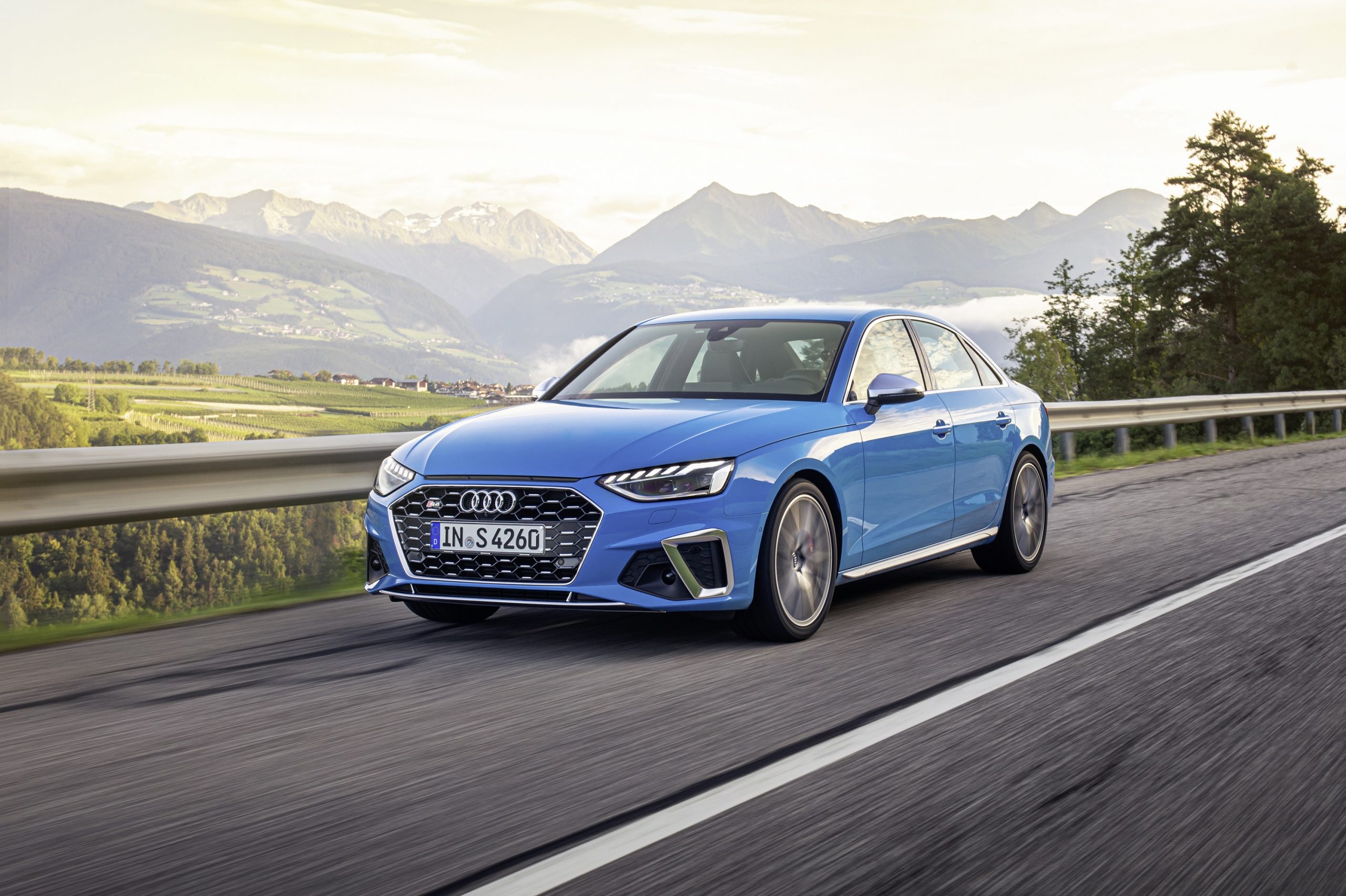 A blue Audi S4 luxury car shot from the front 3/4 on a mountain road