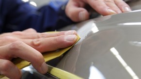 A detailer rubs compound on a car's paint