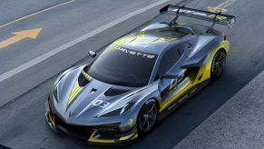 A grey and yellow Chevrolet Corvette C8.R race car shot from the high 3/4 angle in the pit lane