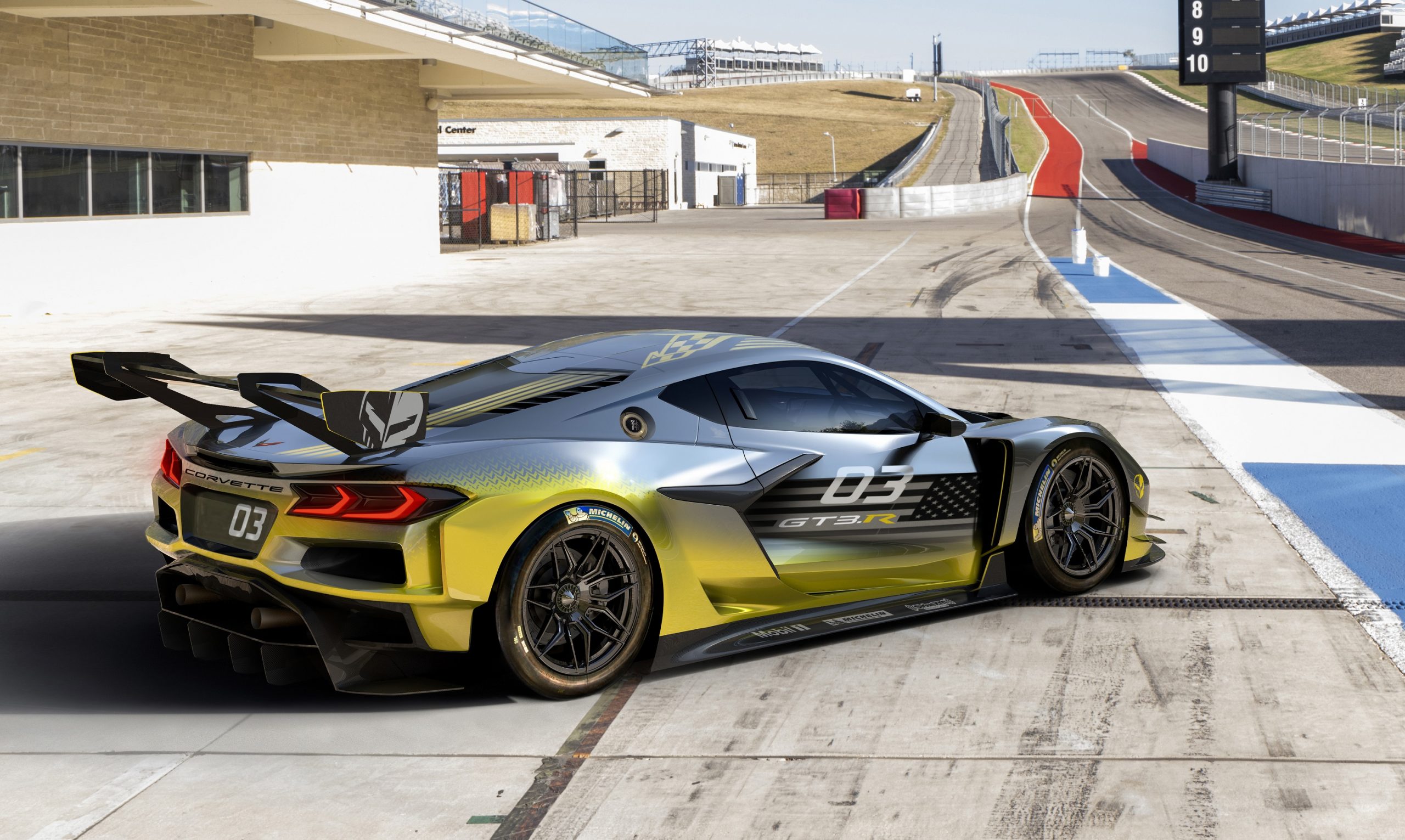 The Corvette GT3.R in yellow and grey shot from the rear 3/4 at the Circuit of the Americas