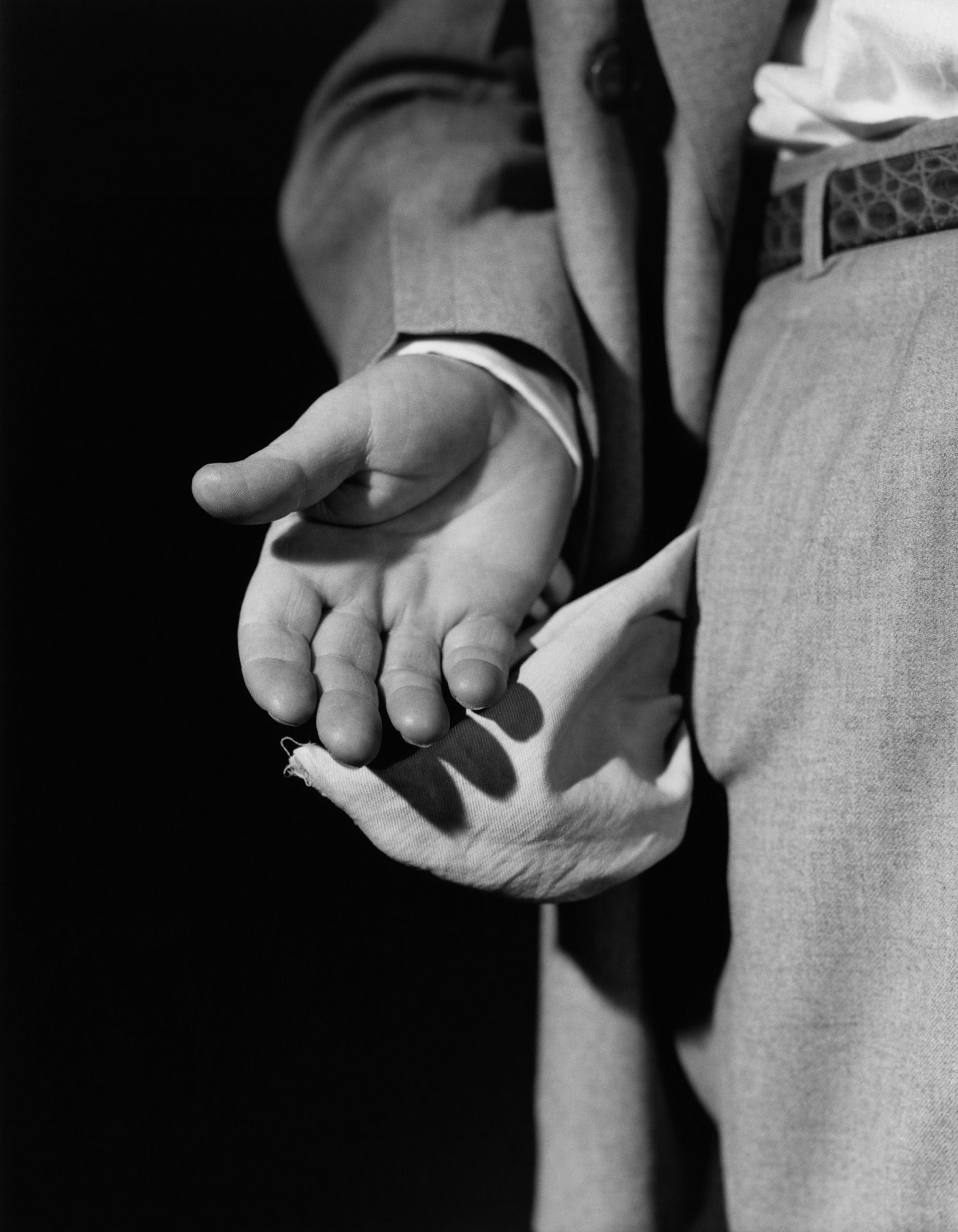 A man holds out empty pockets in a black and white photo