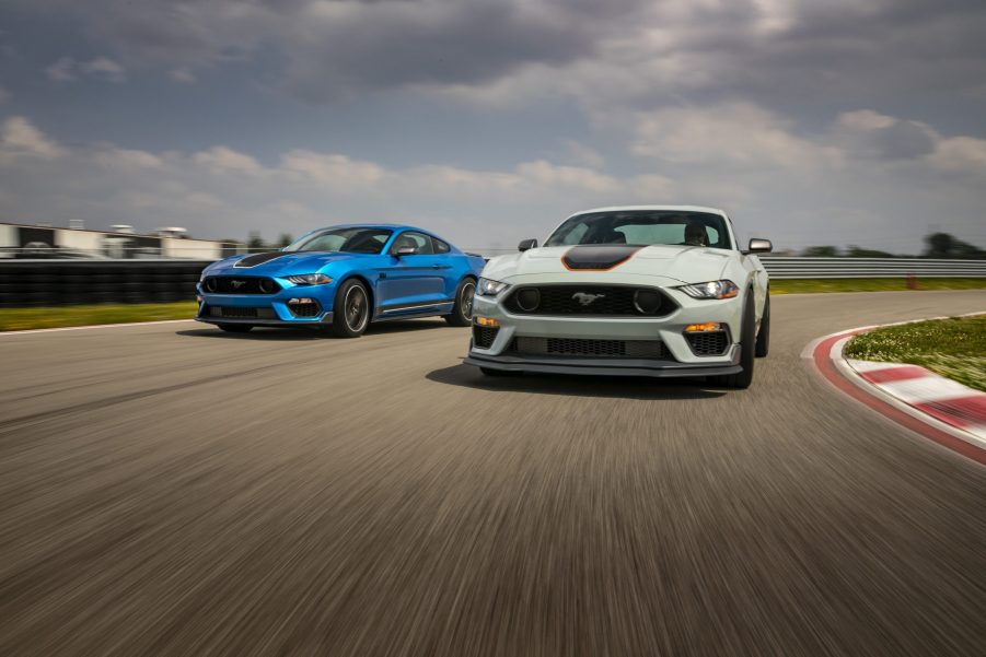 A pair of Ford Mustang Mach 1's in fighter grey and blue shot on a race track from the 3/4 angle